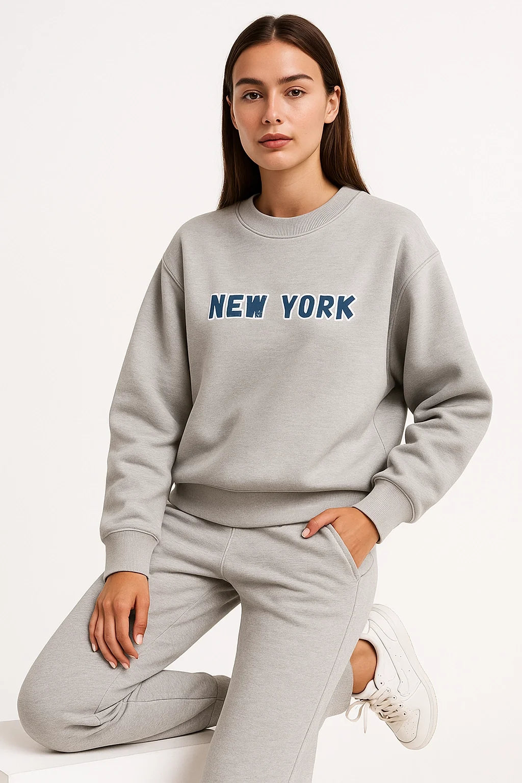 Person wearing a gray sweatshirt with 'New York' text on a white background