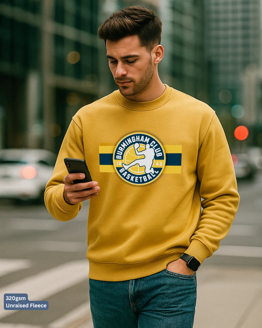 Man wearing a yellow sweatshirt with a logo, standing on a city street.