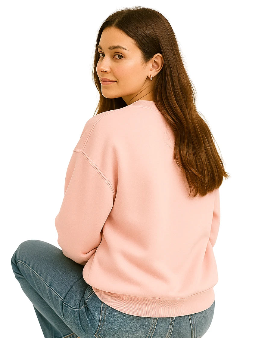 Woman wearing a pink sweatshirt and blue jeans.