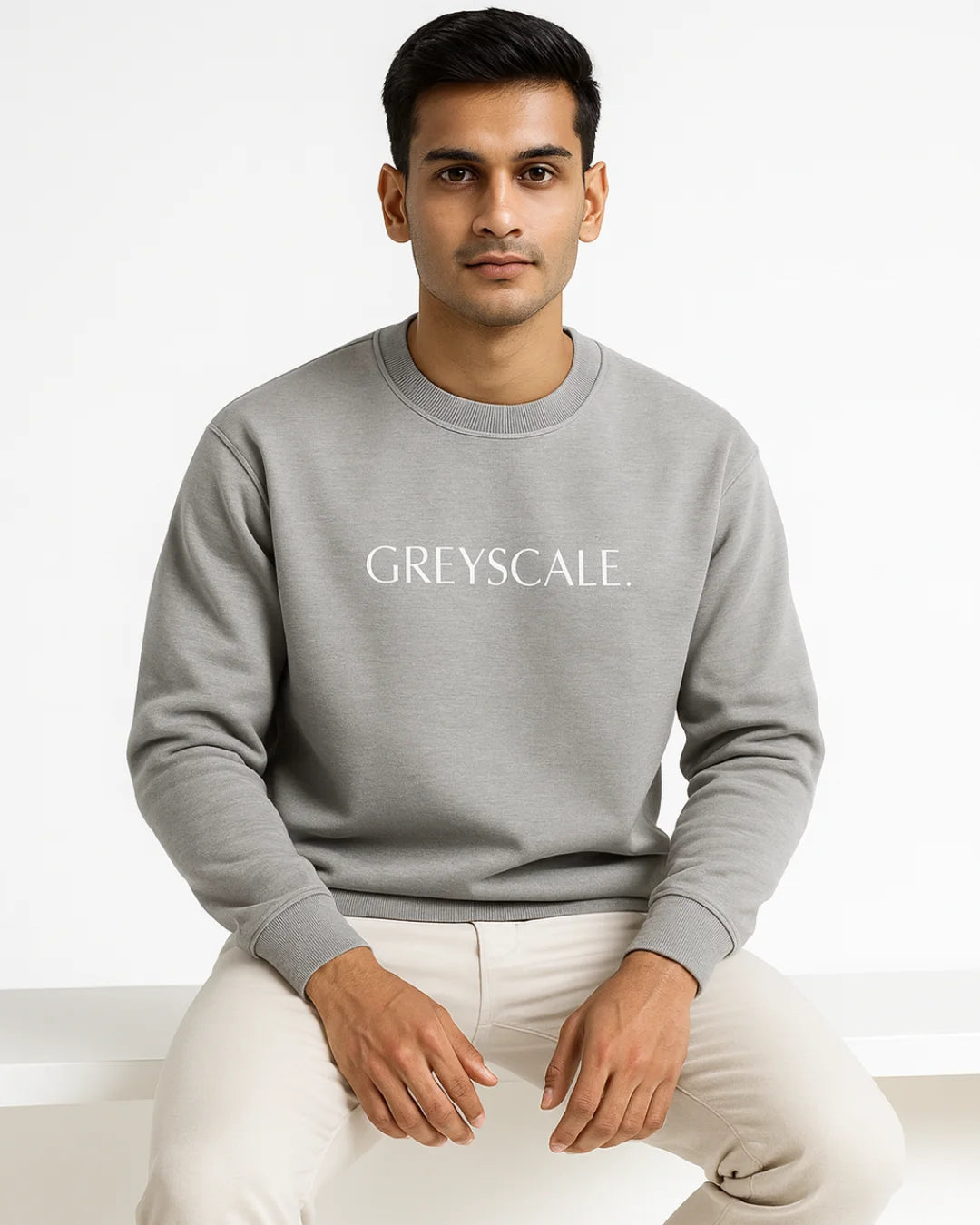 Man wearing a gray sweatshirt with 'GREYSCALE' text on a white background