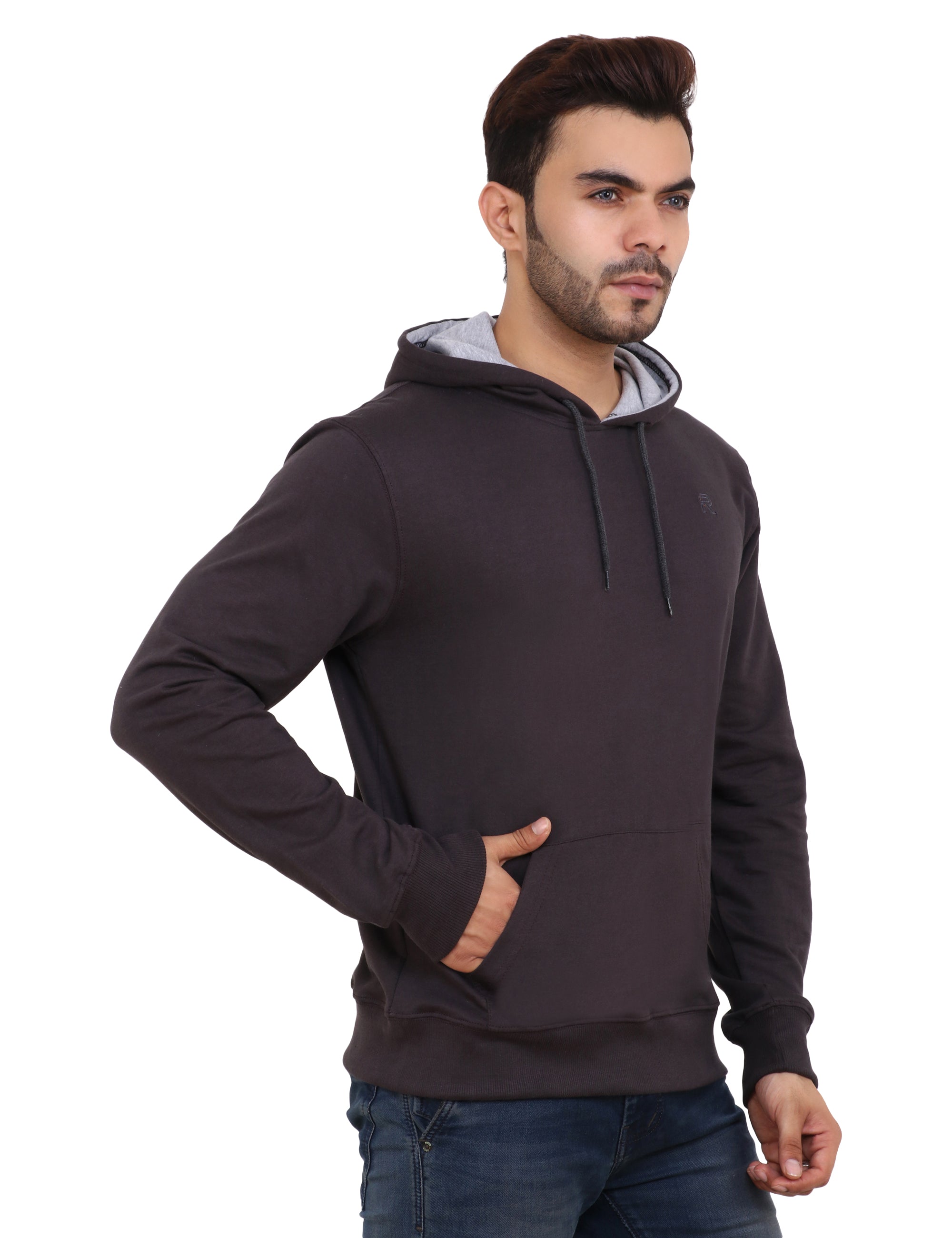 A man wearing a brown hoodie with the hood up, paired with blue jeans.