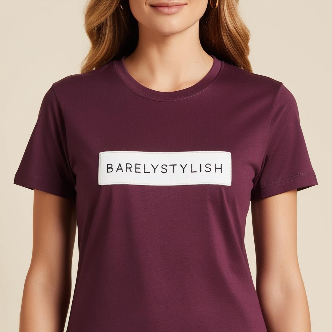 A woman wearing a purple cotton t-shirt with the text 'barelystylish' on it.