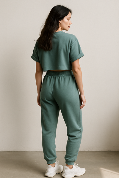 Person wearing a green tracksuit in a studio setting