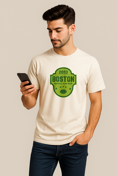 Man wearing a white t-shirt with a green logo and text, holding a phone.