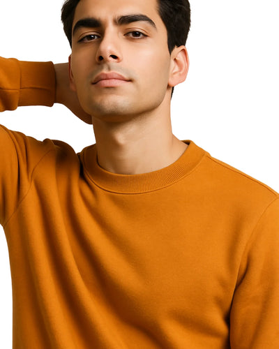 Man wearing an orange sweater against a white background