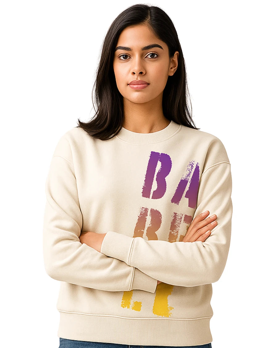 Woman wearing a cream sweatshirt with colorful text on a white background