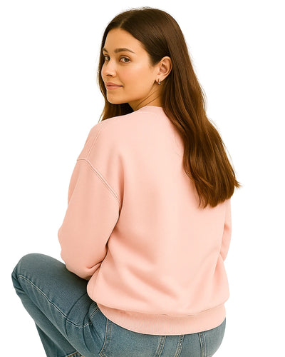 Woman wearing a pink sweatshirt and blue jeans.
