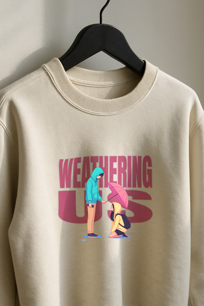 Beige sweatshirt with graphic design of two people and 'WEATHERING CURSES' text on a hanger.
