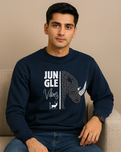 Man wearing a navy blue sweatshirt with text and graphics, sitting on a beige couch.
