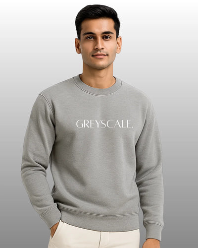 Man wearing a gray sweatshirt with 'GREYSCALE' text on a plain background