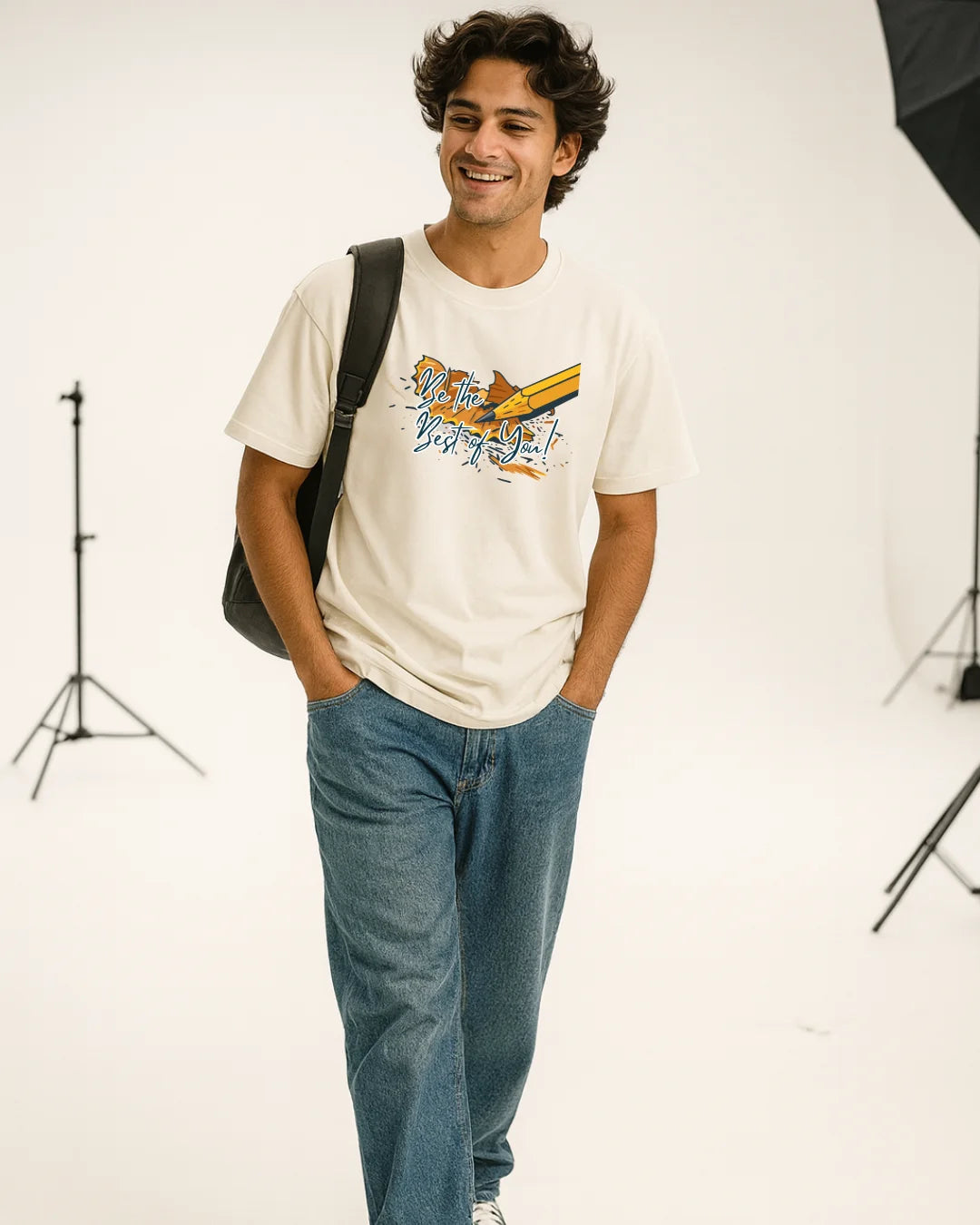 Man wearing a white t-shirt with a graphic design and blue jeans, standing against a white background.
