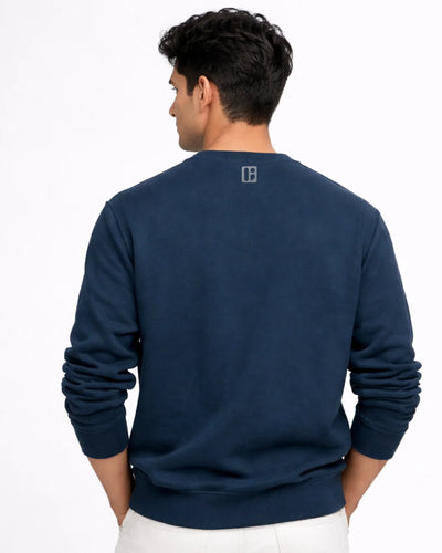 Man wearing a navy blue sweatshirt with a logo on the back against a white background