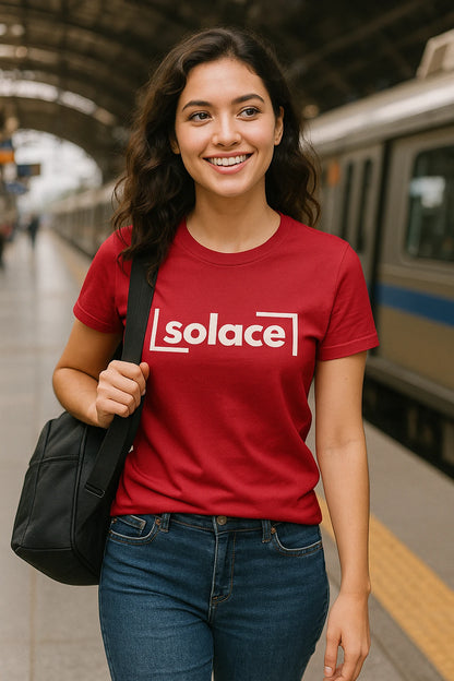 Woman wearing a red 'solace' t-shirt at a train station.