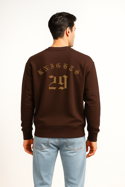 Man wearing a brown sweatshirt with 'Knights 29' text on the back, standing against a white background