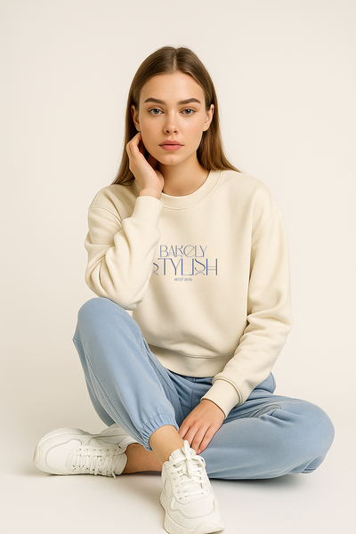 Woman wearing a cream sweatshirt with light blue pants.